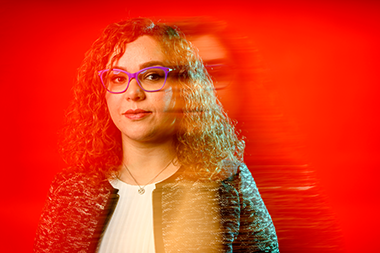 Headshot of Serena Alexander with a red background 