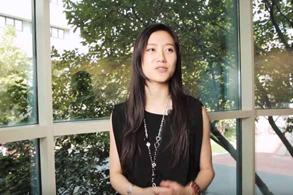 Asian woman speaking with trees in background