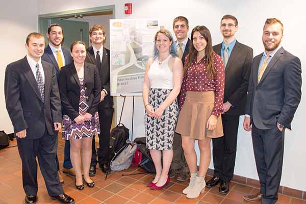 group of students in front of poster they presented