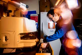 Aron Stubbins, associate professor of marine & environmental sciences and civil & environmental engineering, inspects microplastics from the open ocean.